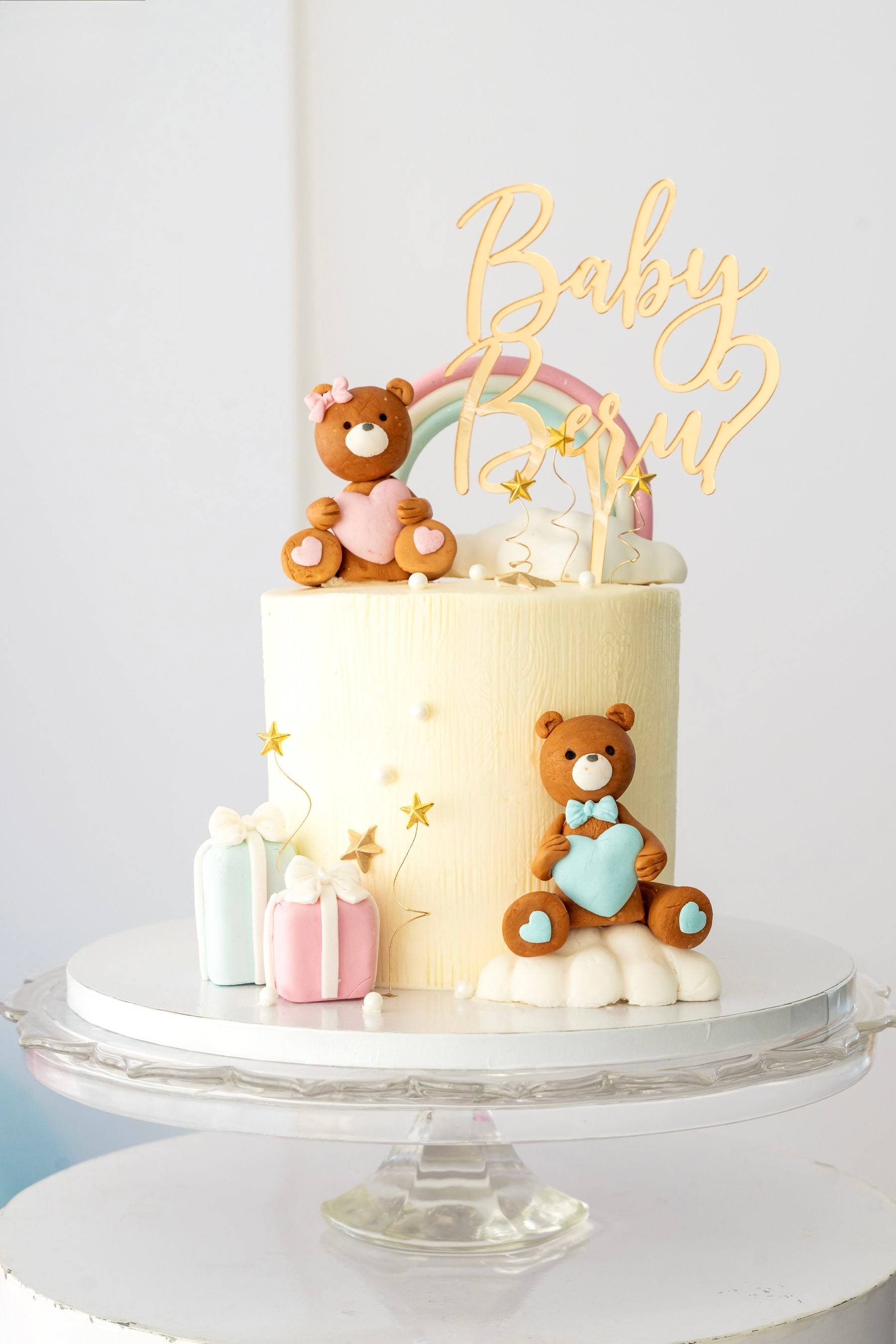 Teddy bear and rainbow cake on a glass cake stand