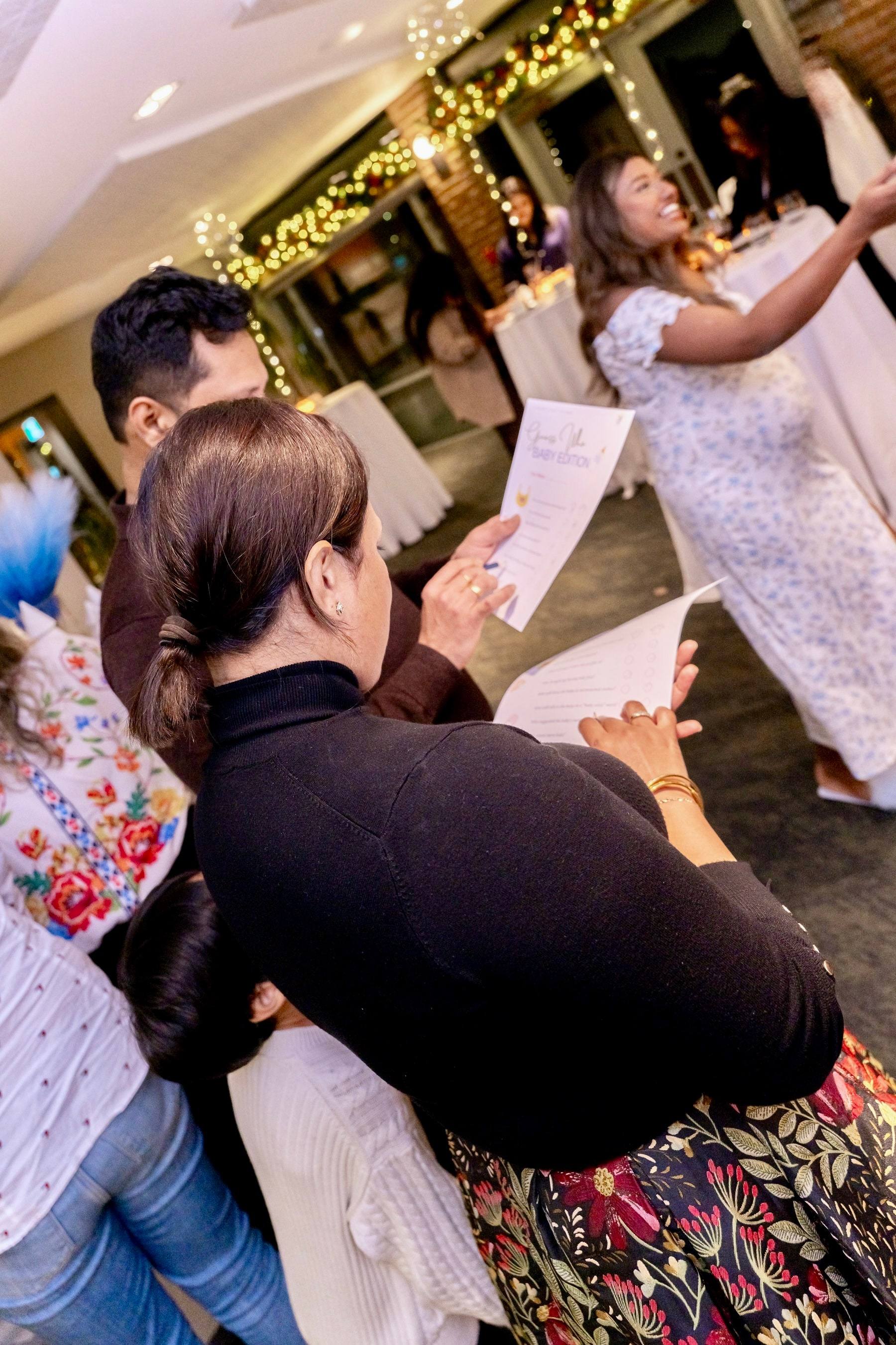 Guests laughing while playing a baby shower game