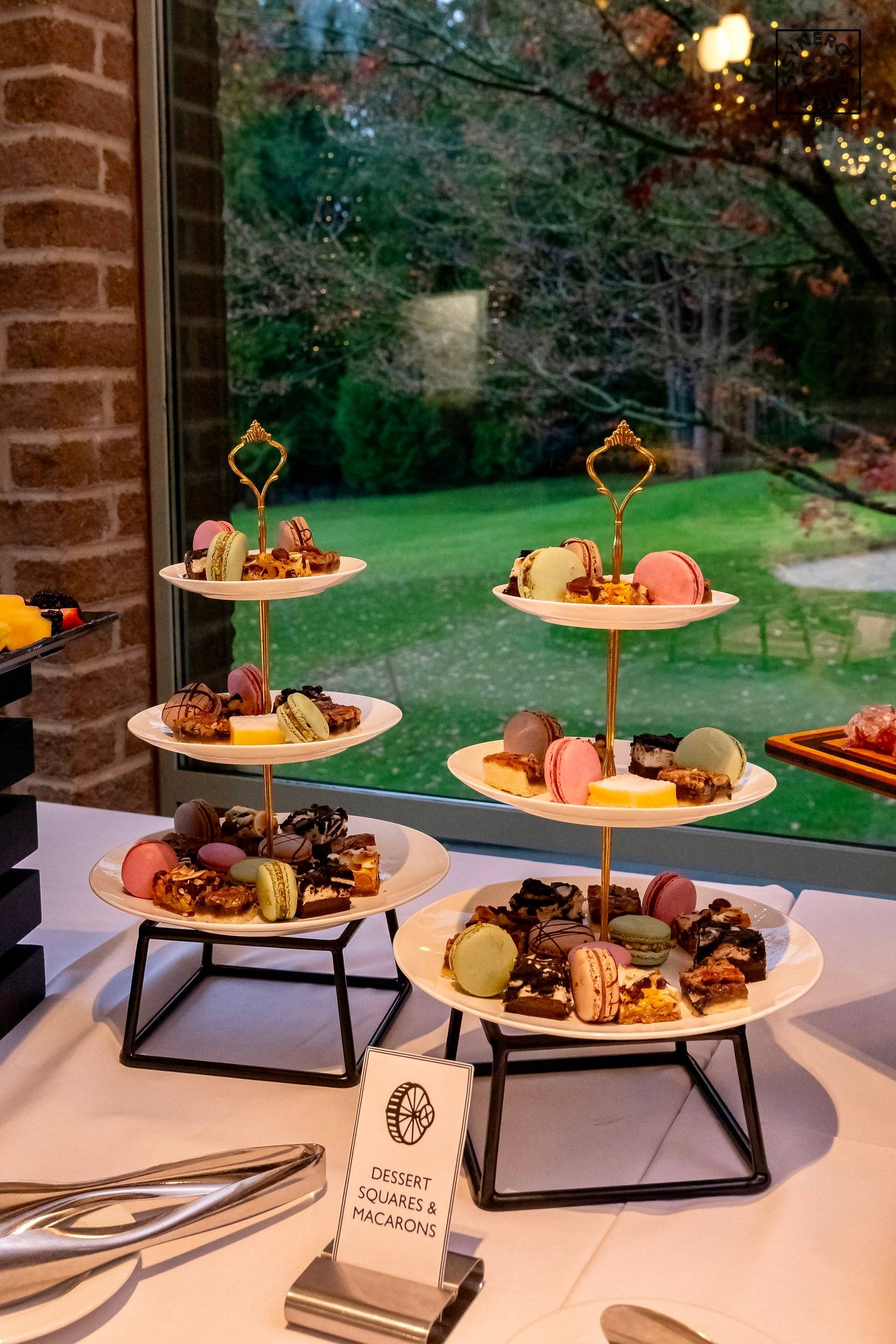 Tiered dessert stands of pastries and macarons by the window
