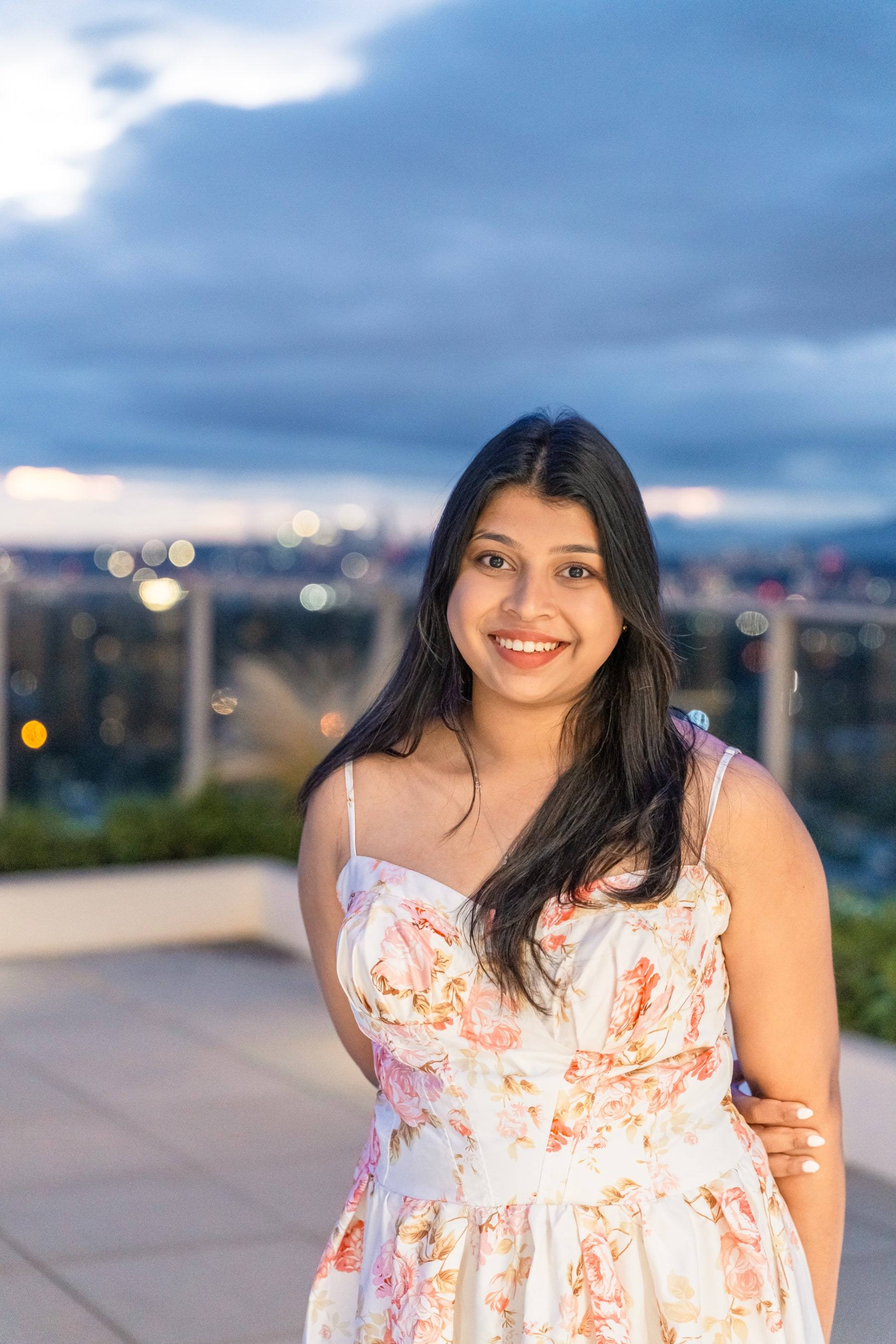 Smiling birthday girl on a city rooftop with the skyline behind her