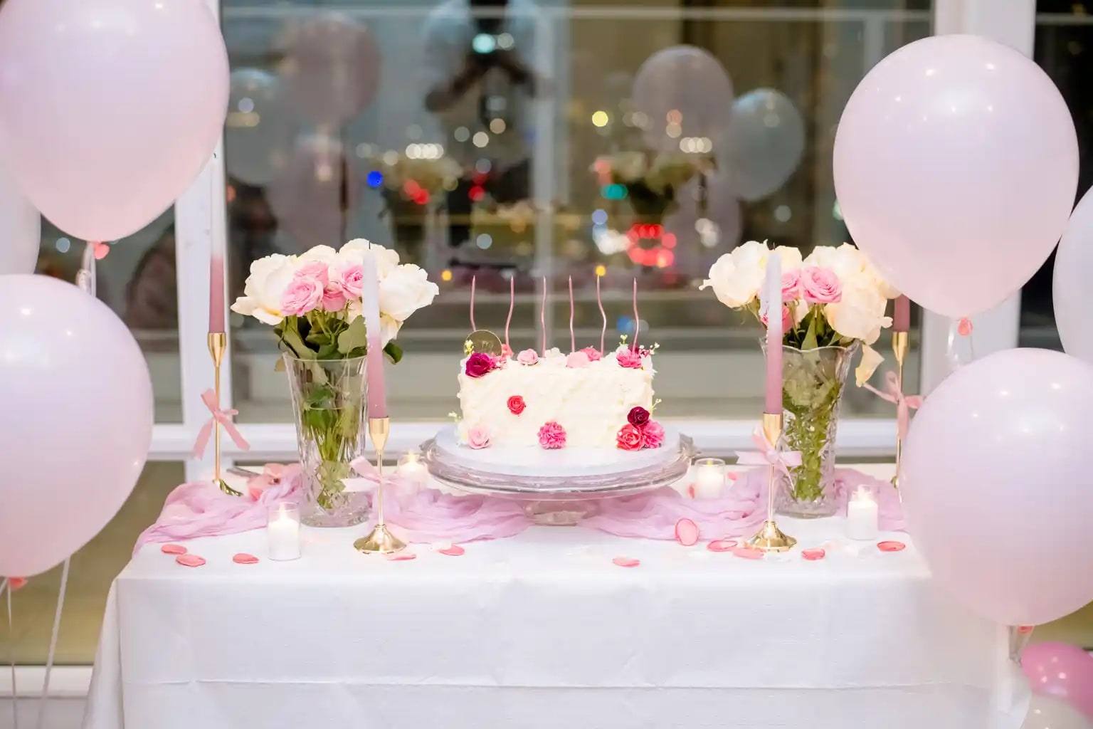 Birthday cake table with pink roses and balloons