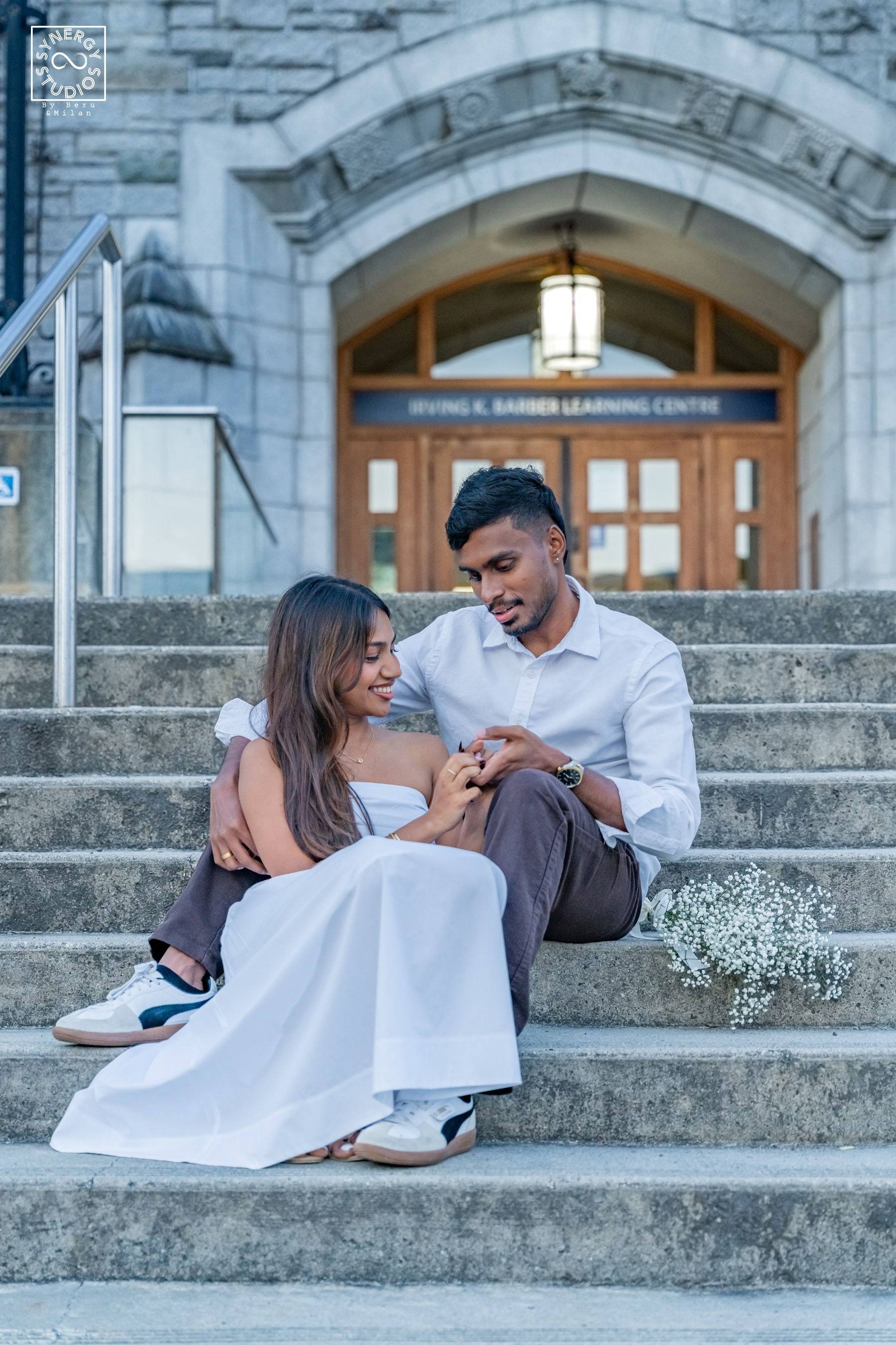 Couple sitting close on the steps of a historic stone building