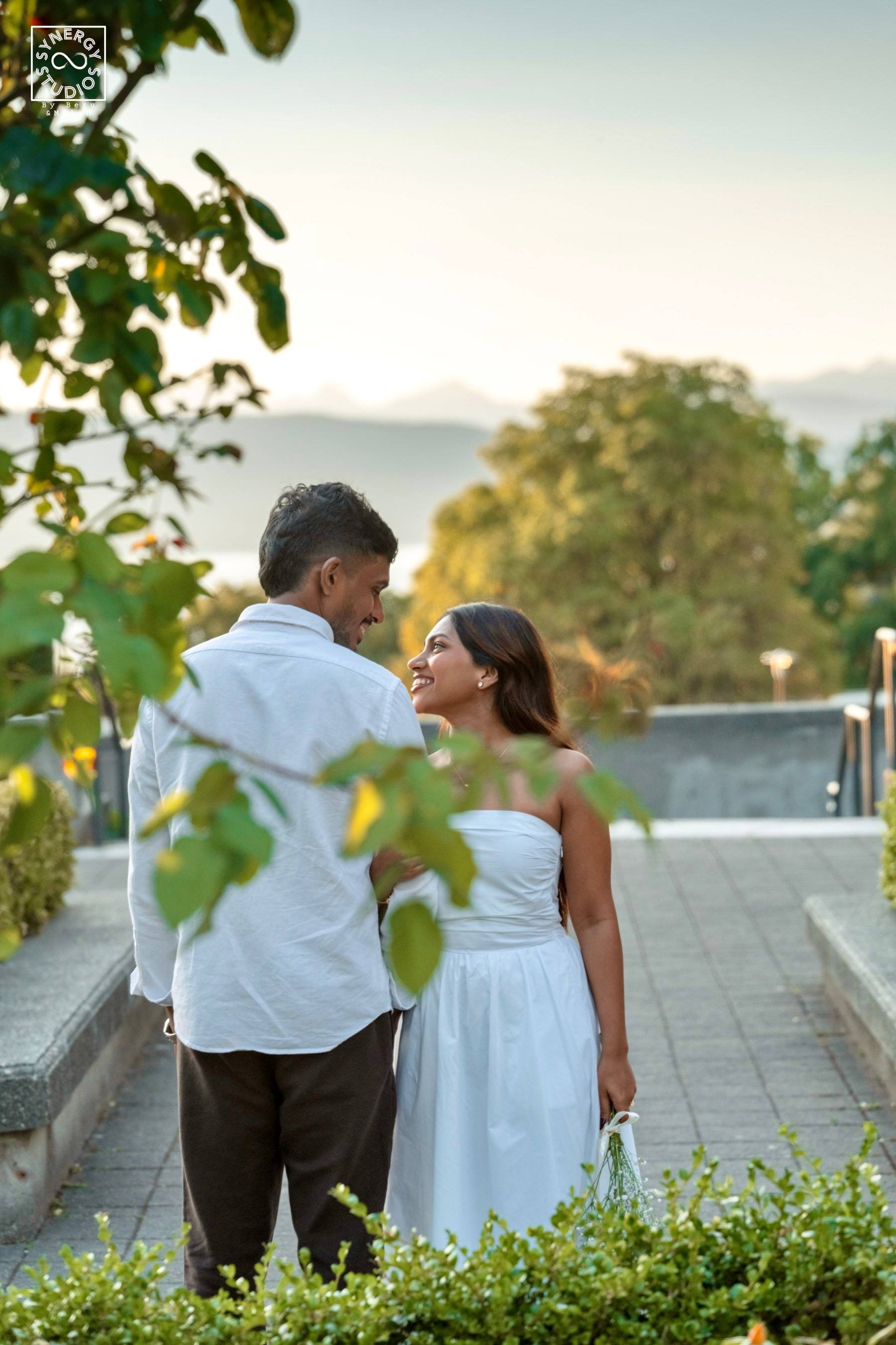 Couple gazing at each other with sunset light and mountains behind them