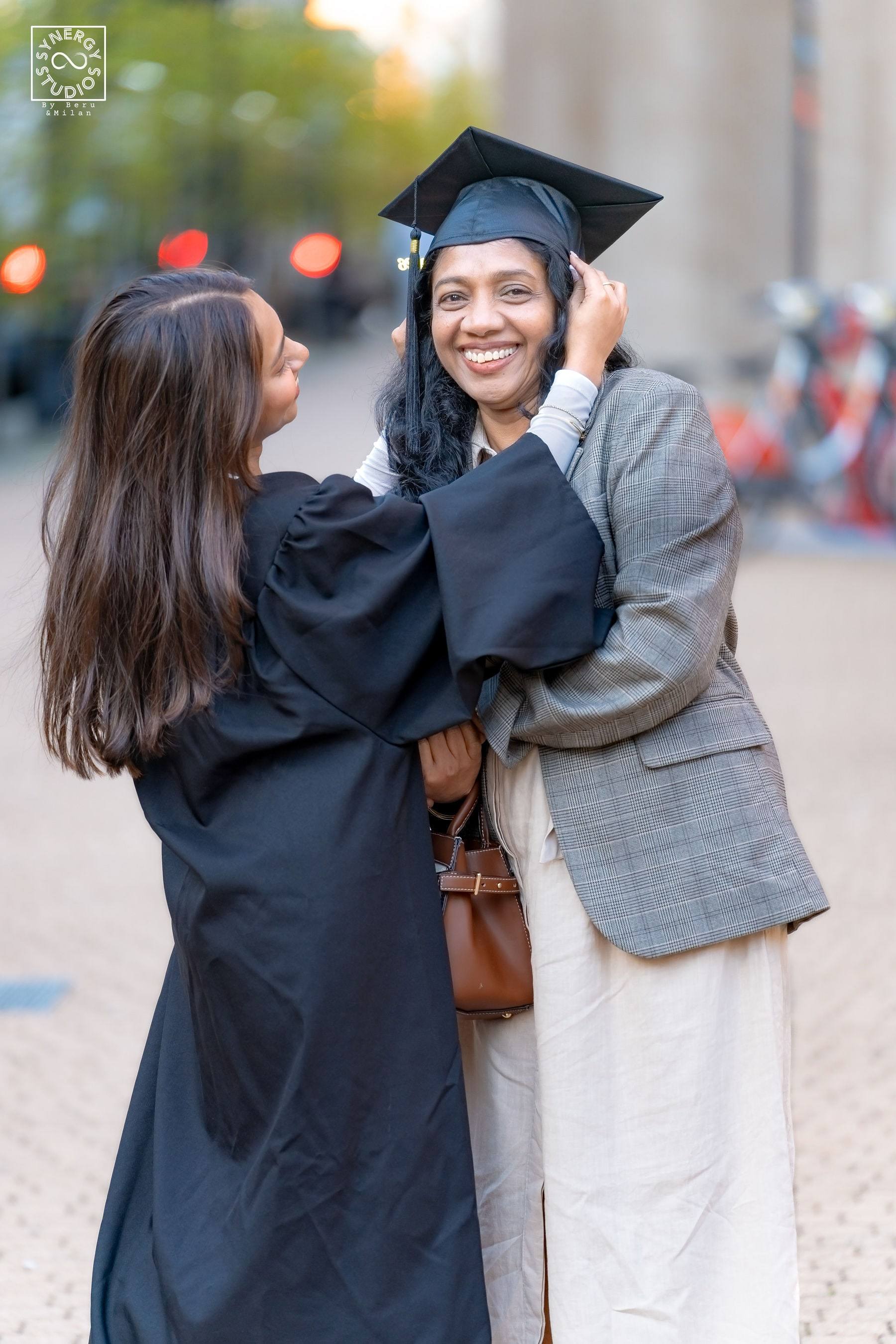 Mother adjusting her daughter's graduation cap with a warm smile