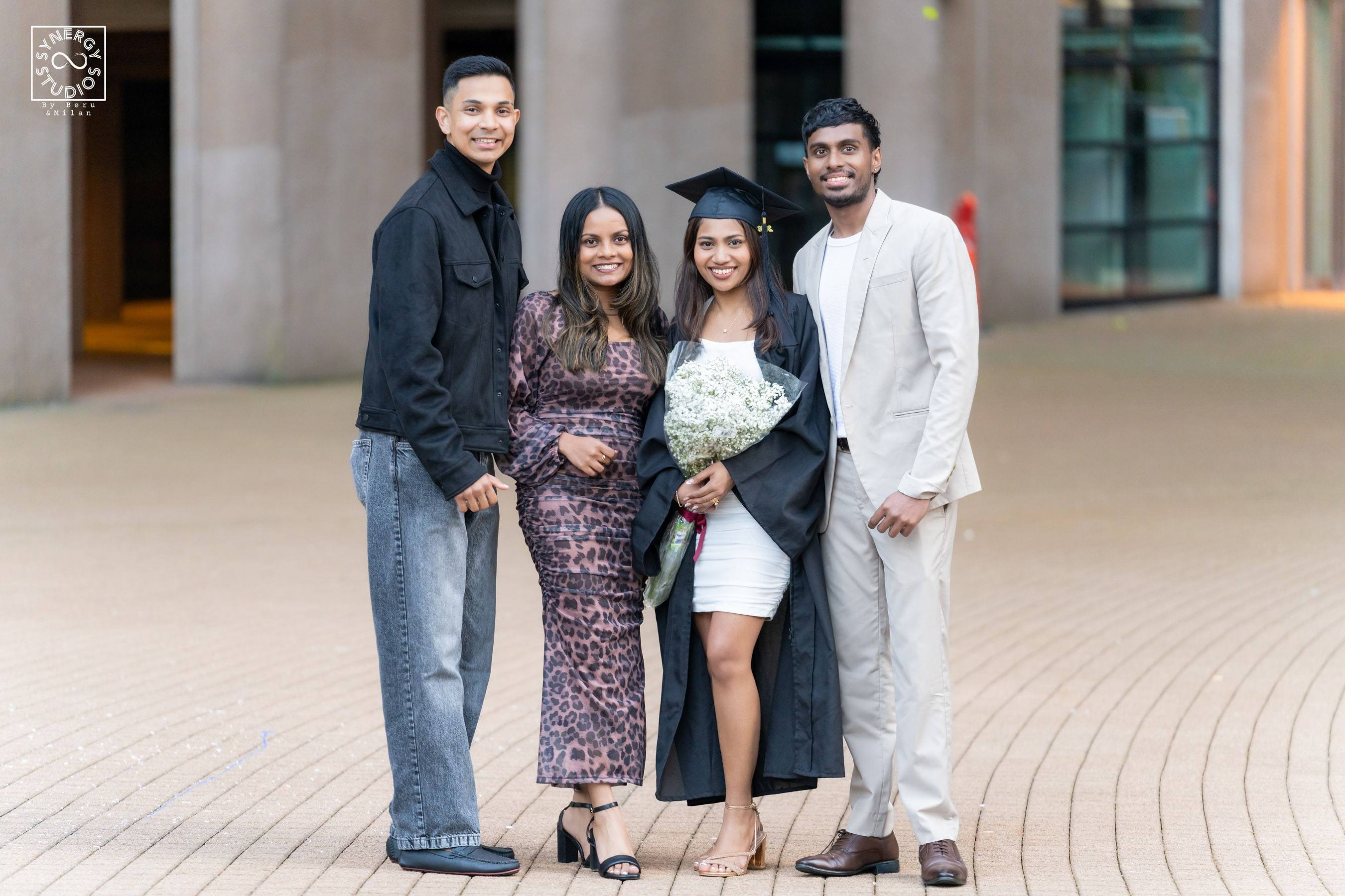 Graduate with her family group on a campus walkway