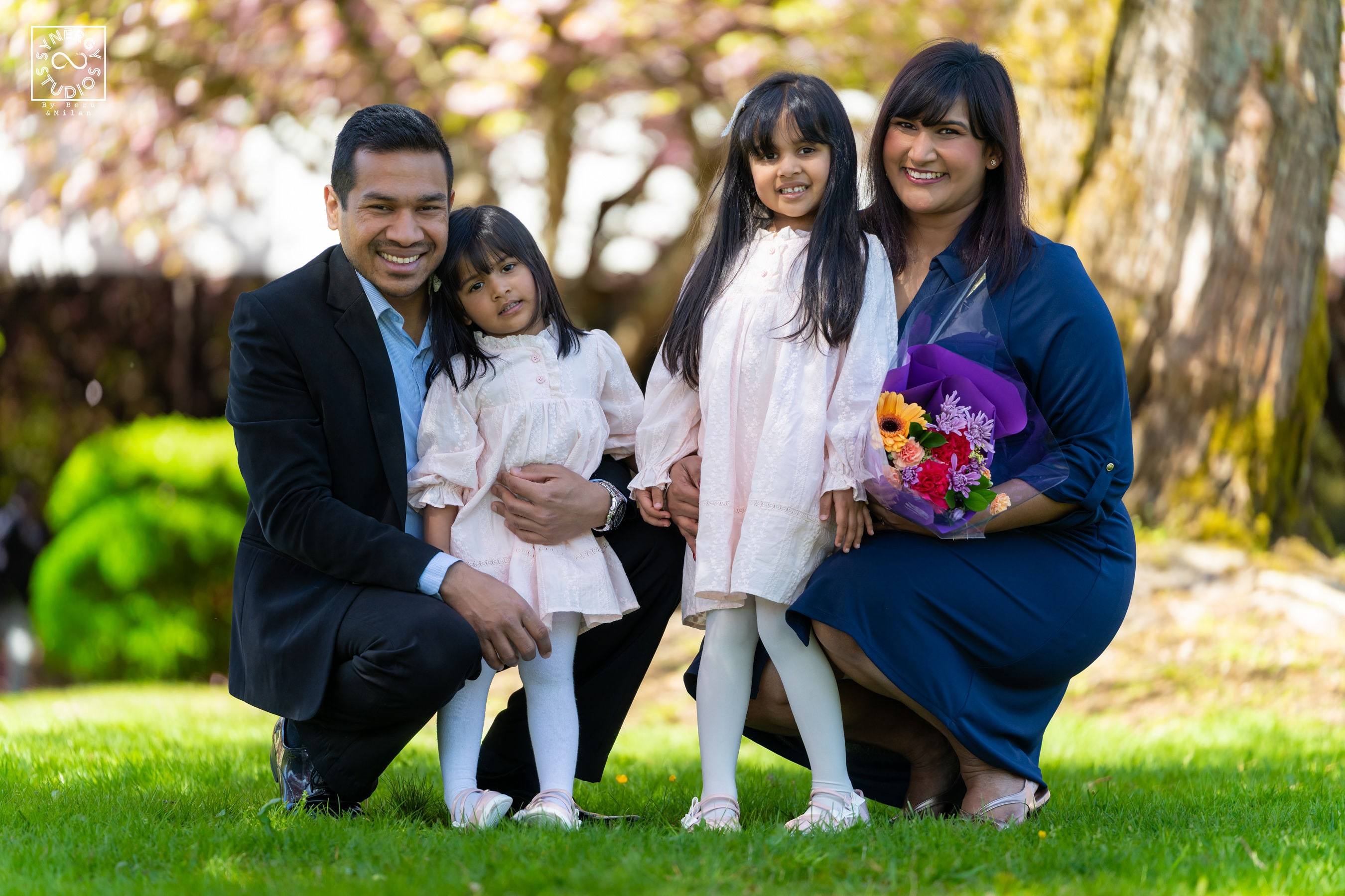 Graduate and her family kneeling together on the grass
