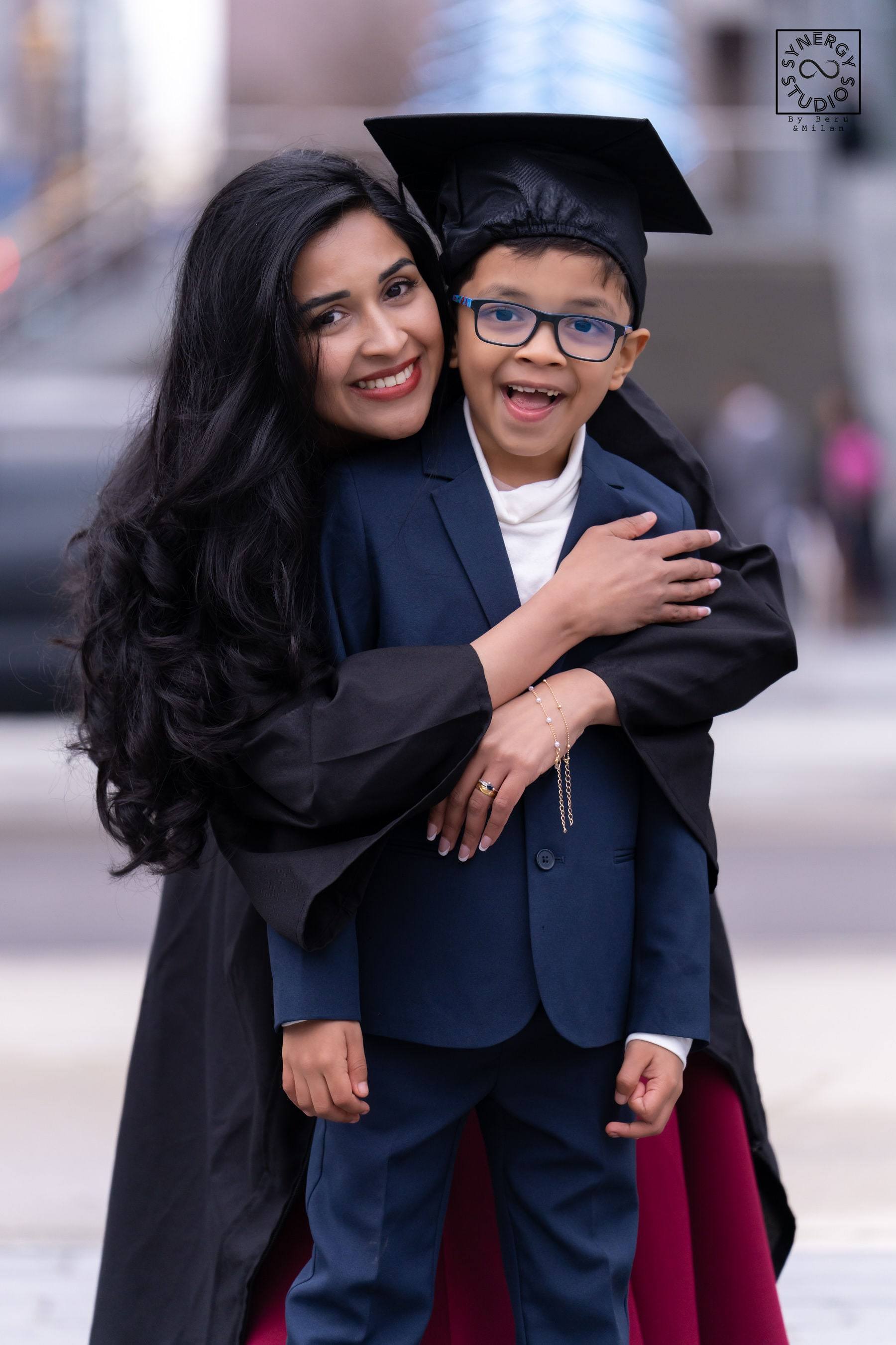 Graduate hugging her son who is wearing her graduation cap