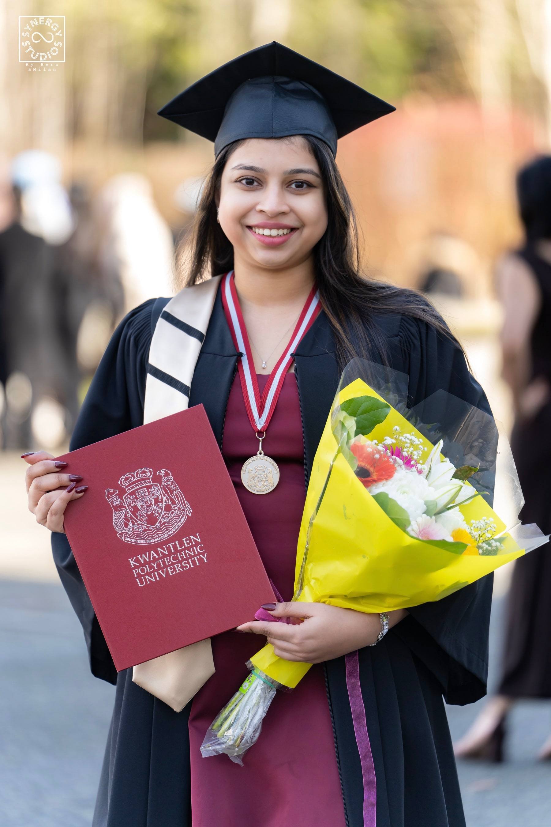 Graduate with her medal, diploma and a yellow bouquet