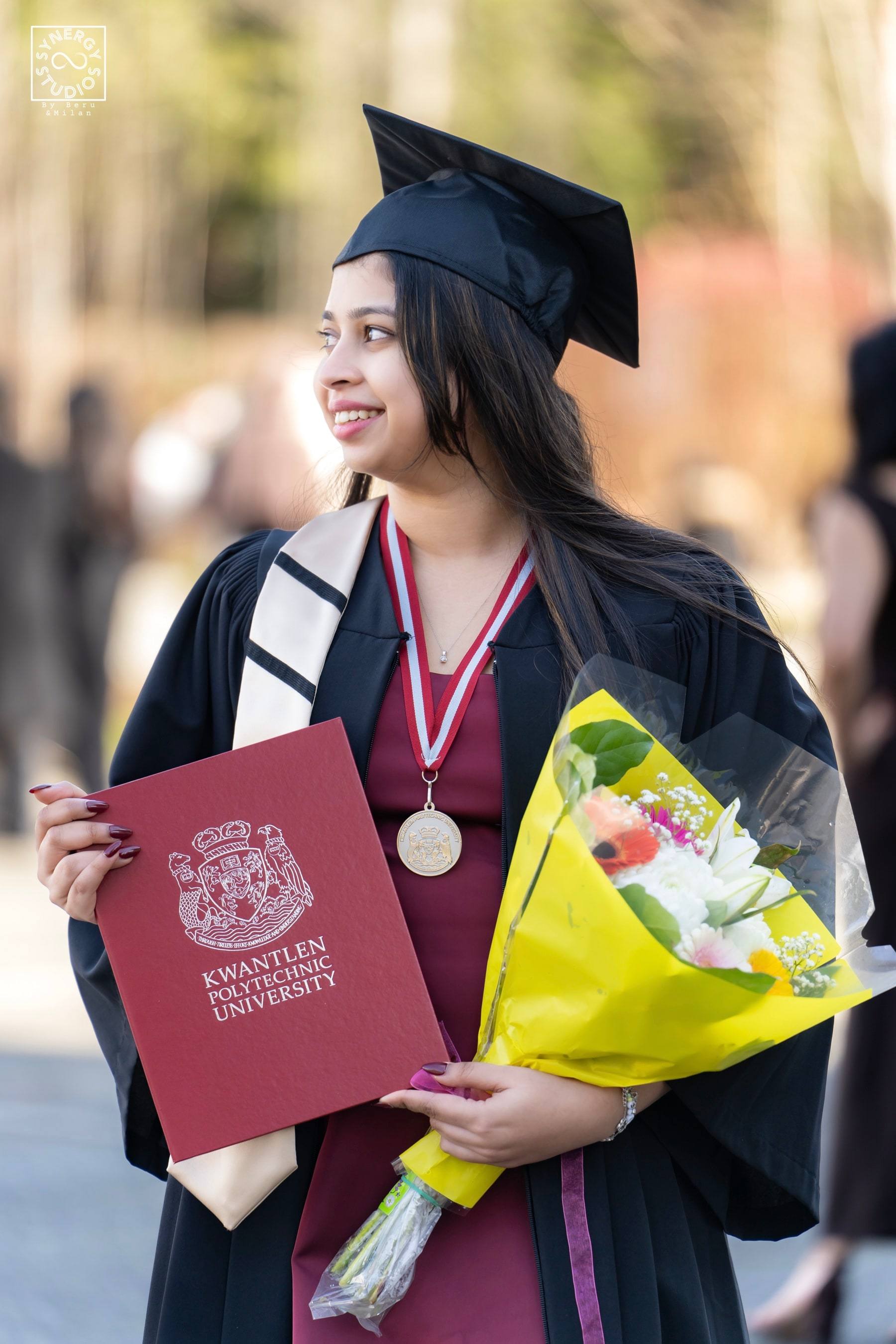 Smiling graduate holding a yellow bouquet and red diploma folder